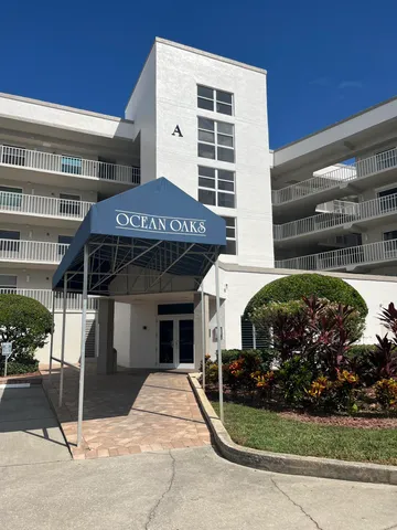 a view of a house with a small yard and potted plants