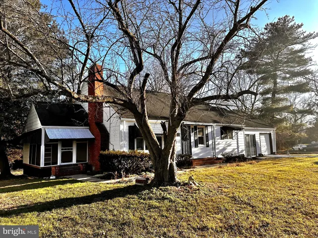 a front view of a house with a yard large trees
