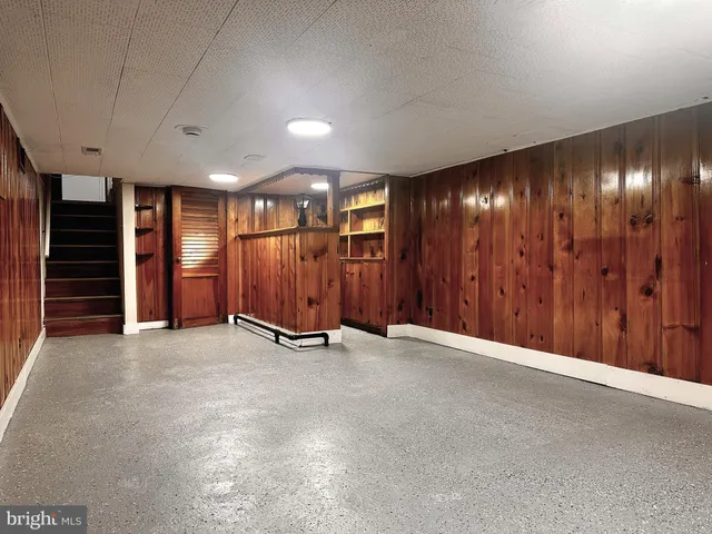 a backyard of a house with plants and large trees