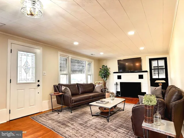 an empty room with wooden floor fireplace and windows