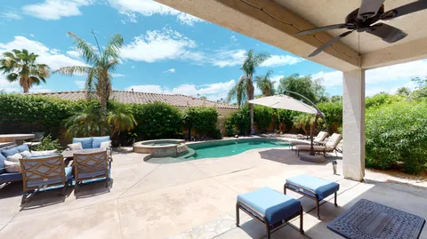 a view of a patio with a table and chairs under an umbrella