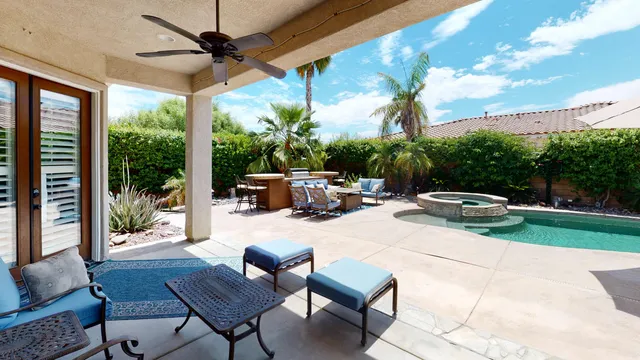 a view of a patio with a table chairs and a backyard
