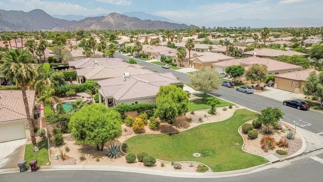 an aerial view of a house with a garden and lake view