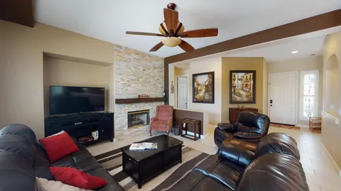 a living room with furniture a flat screen tv and a fireplace