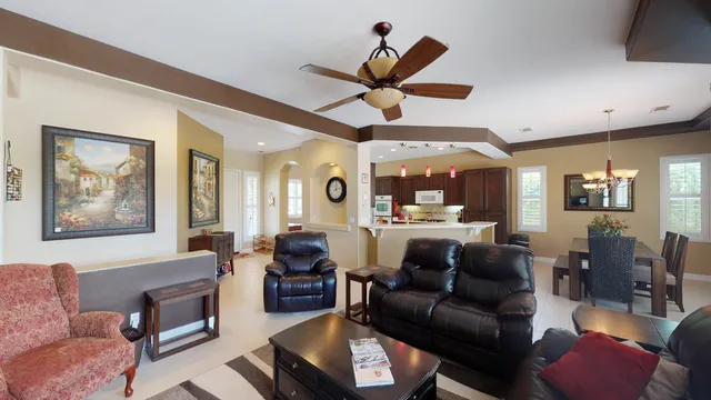 a living room with furniture a ceiling fan and a window