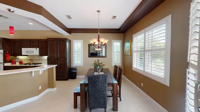 a kitchen with granite countertop a stove a sink dishwasher a dining table and chairs with wooden floor