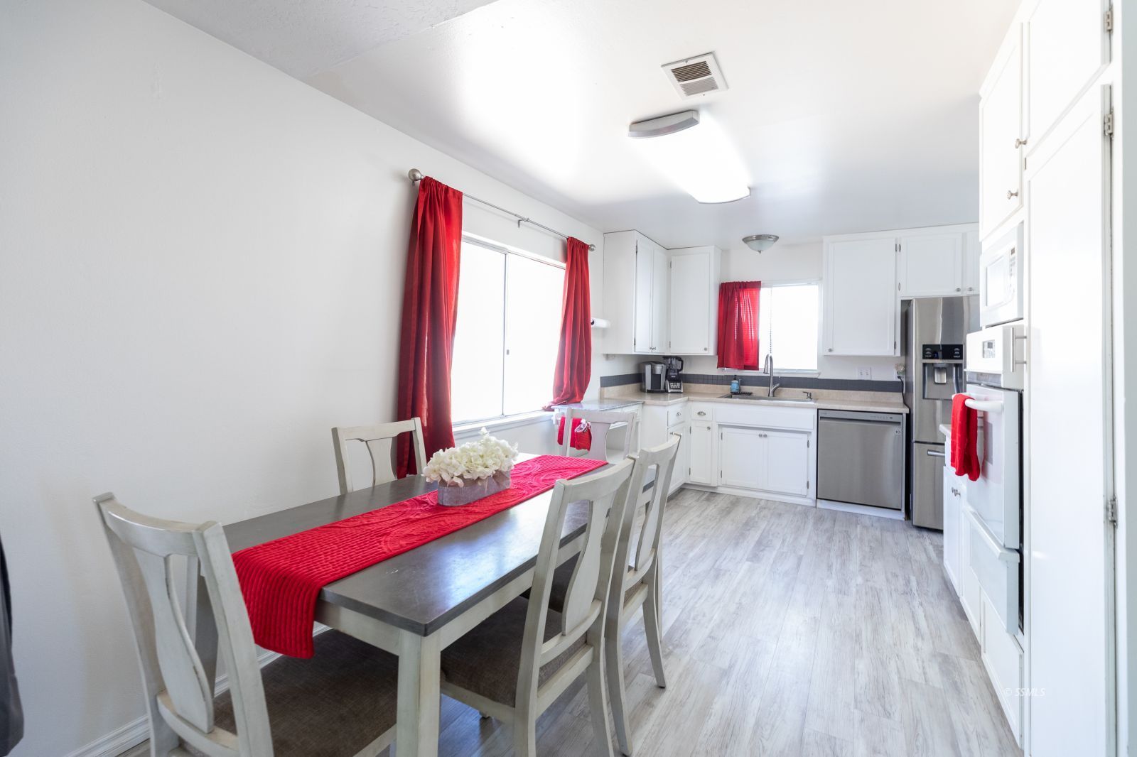 317 South Silver Ridge Street Ridgecrest, CA 93555 - Photo 11 of 28 a kitchen with a dining table chairs sink and cabinets