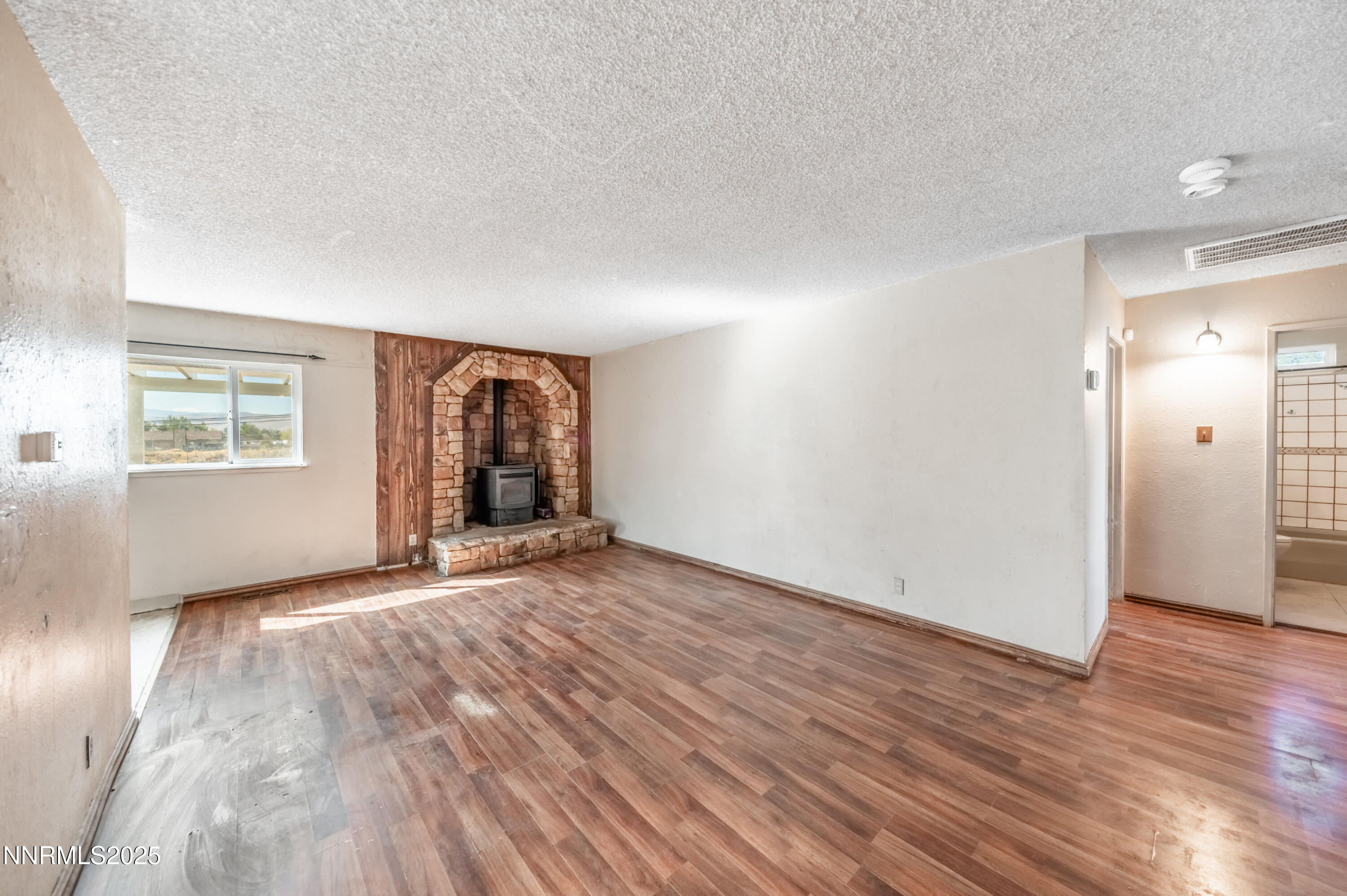 11890 Chesapeake Drive Reno, NV 89506 - Photo 3 of 33 an empty room with wooden floor and windows
