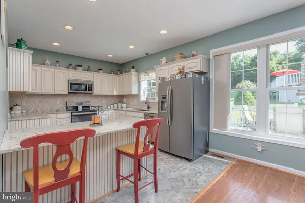 a kitchen with granite countertop a sink stainless steel appliances and cabinets