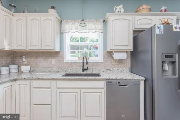 a kitchen with stainless steel appliances granite countertop a refrigerator sink and cabinets
