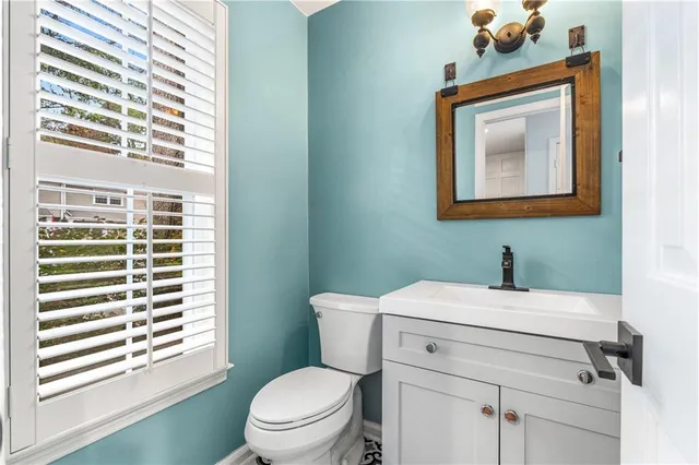 a bathroom with a toilet a sink and a mirror