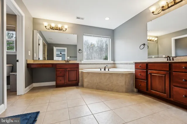 a large spacious bathroom with a large tub shower and sink