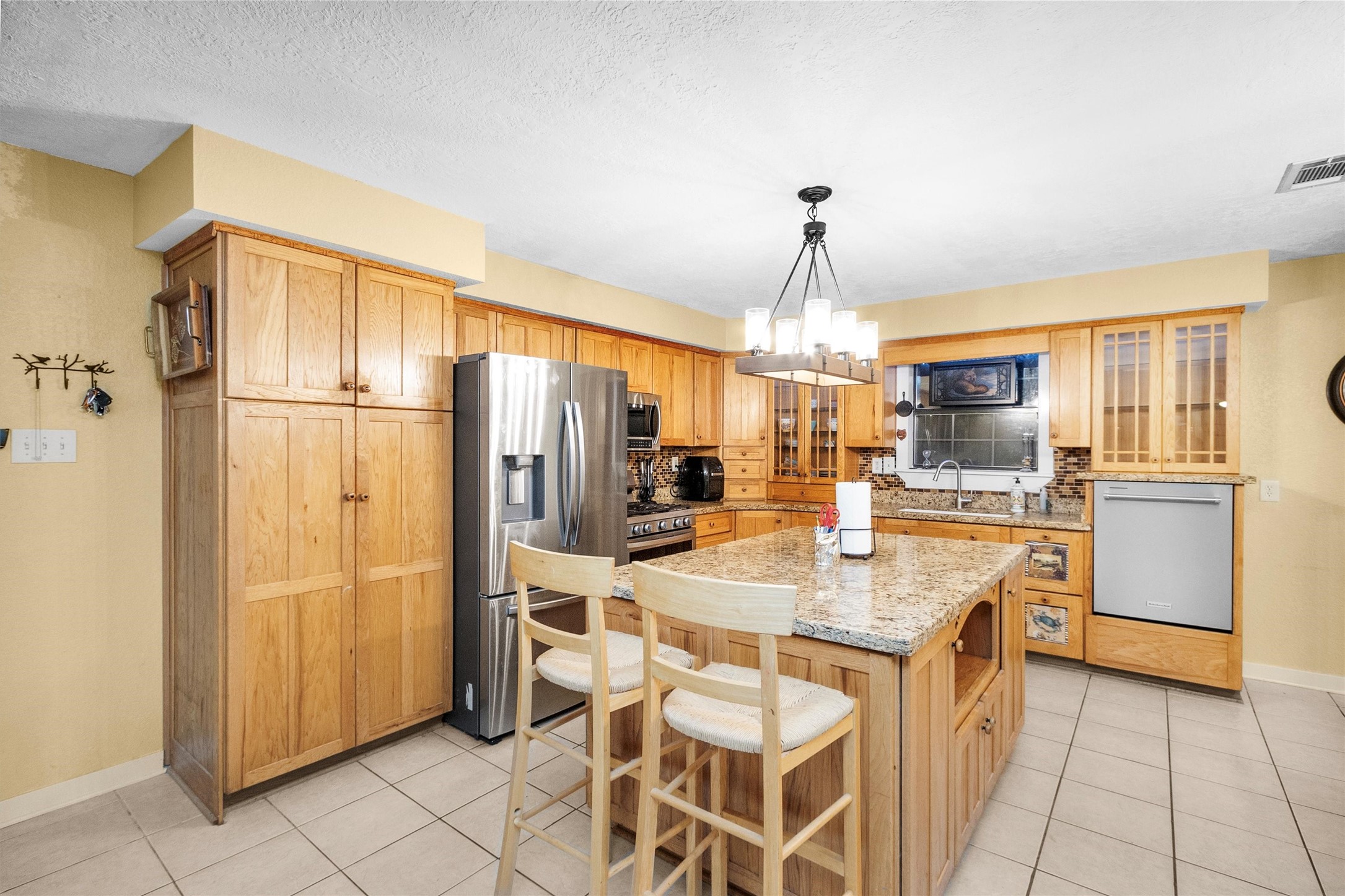 528 Catfish Lane Conroe, TX 77384 - Photo 17 of 49 a kitchen with stainless steel appliances granite countertop a refrigerator a stove and a sink