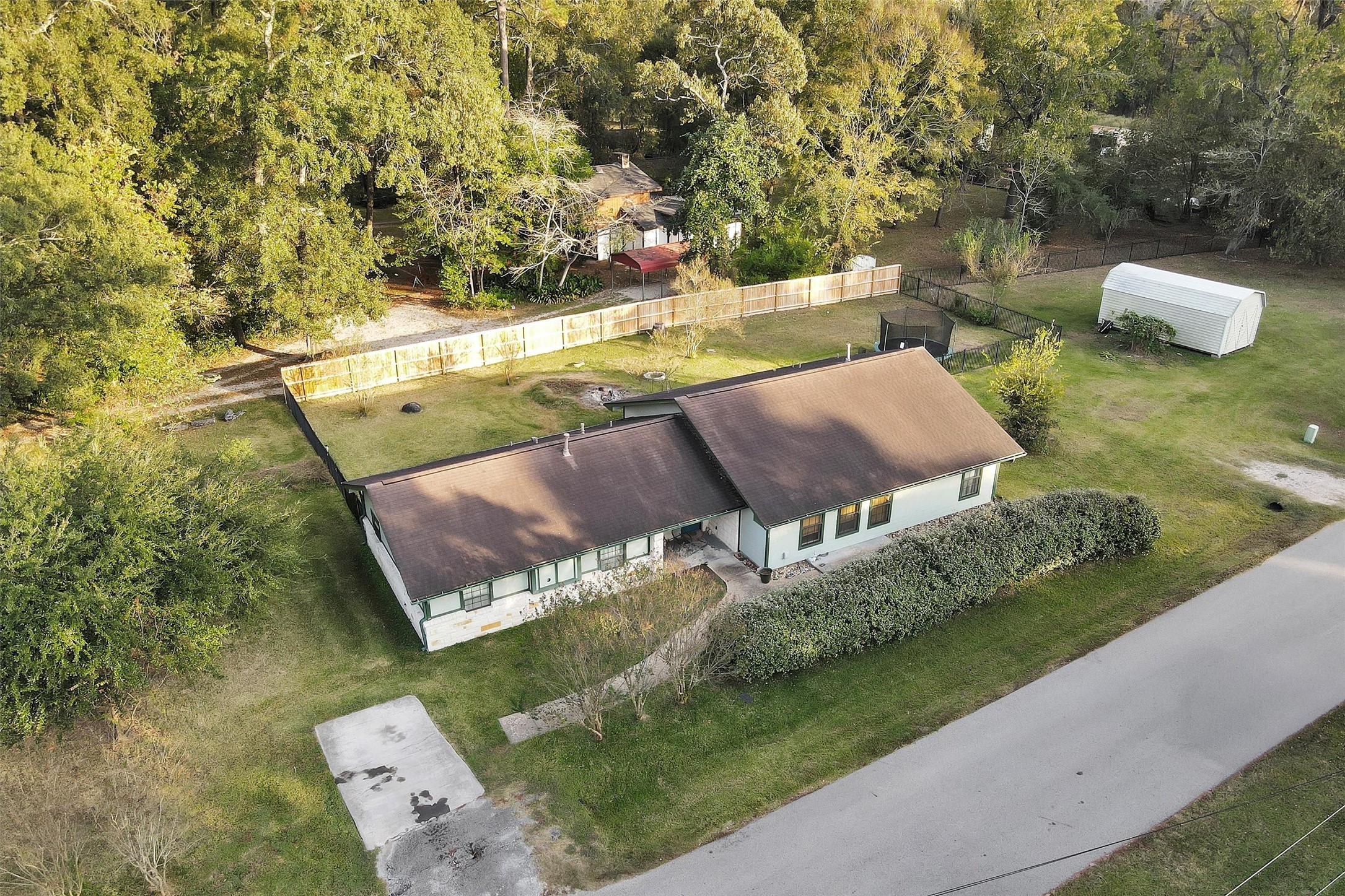 528 Catfish Lane Conroe, TX 77384 - Photo 37 of 49 a view of a backyard with lawn chairs under an umbrella