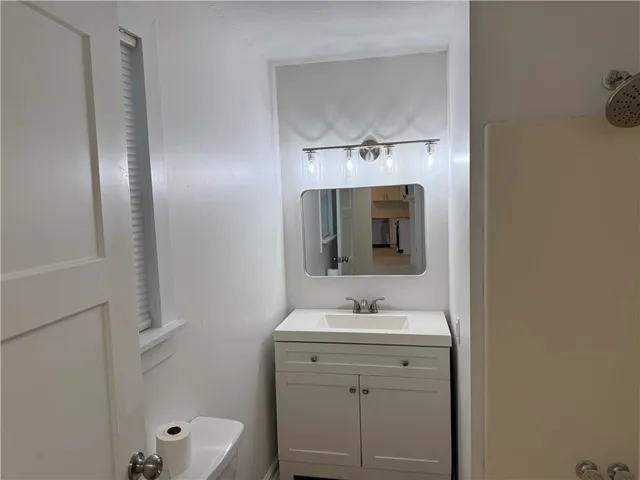 a bathroom with a toilet sink and mirror