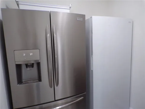 a metallic refrigerator freezer sitting in a kitchen