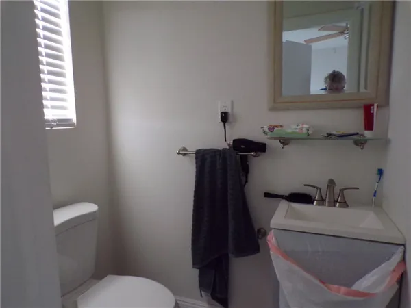 a bathroom with a toilet sink and mirror