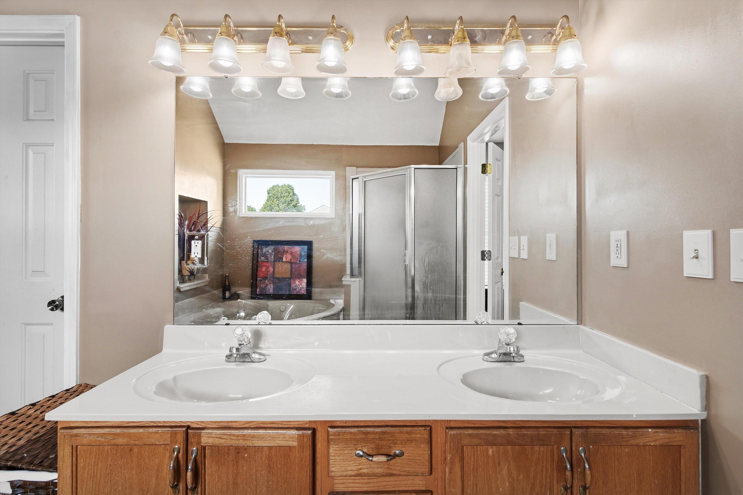 7779 Windy Willow Road Memphis, TN 38125 - Photo 17 of 30 Dual vanity featuring white integrated sinks and a light-toned countertop set atop a wood-finish cabinet