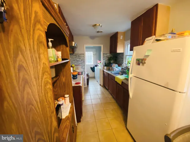 a dining room with stainless steel appliances kitchen island granite countertop a table chairs in it and a wooden floor