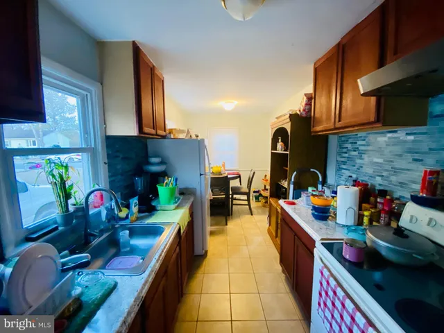 a utility room with dryer washer and a view of living room