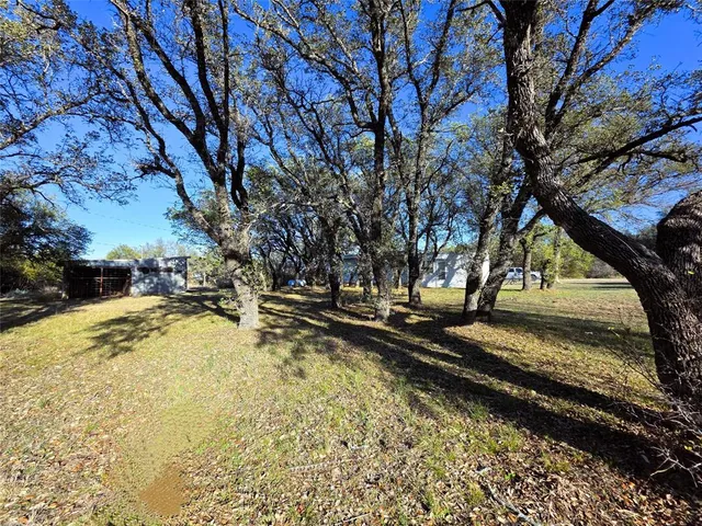 a view of a yard with wooden fence