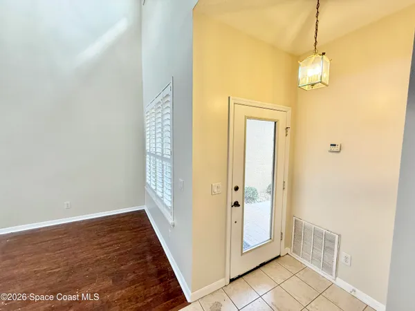 a view of a hallway with wooden floor and a bathroom