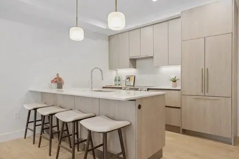 a kitchen with stainless steel appliances a table chairs and white cabinets