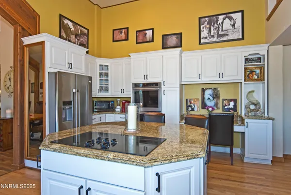 a kitchen with stainless steel appliances granite countertop a refrigerator a stove and a wooden floors