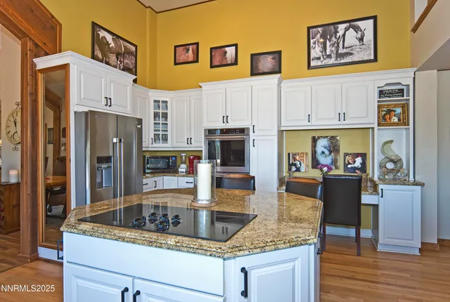 a kitchen with stainless steel appliances granite countertop a refrigerator a stove and a wooden floors