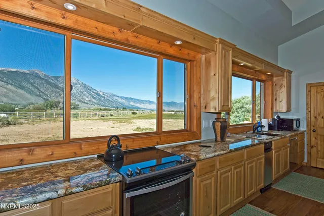 a kitchen with stainless steel appliances granite countertop sink stove and large window