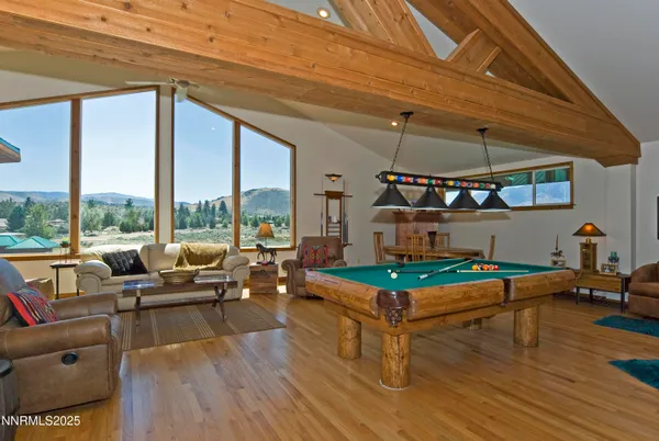 a living room with furniture a rug and a floor to ceiling window