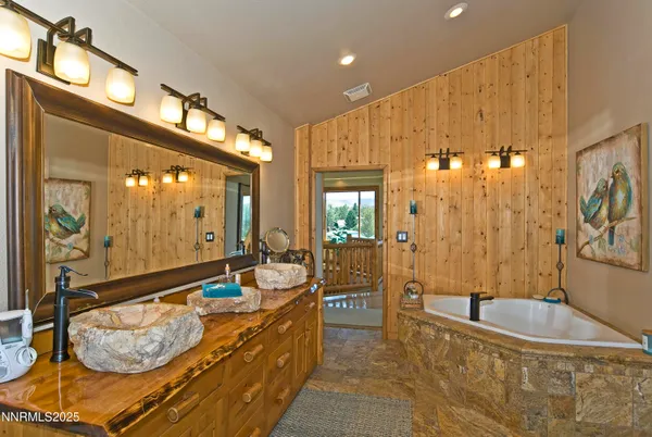 a bathroom with a tub a double vanity sink and mirror
