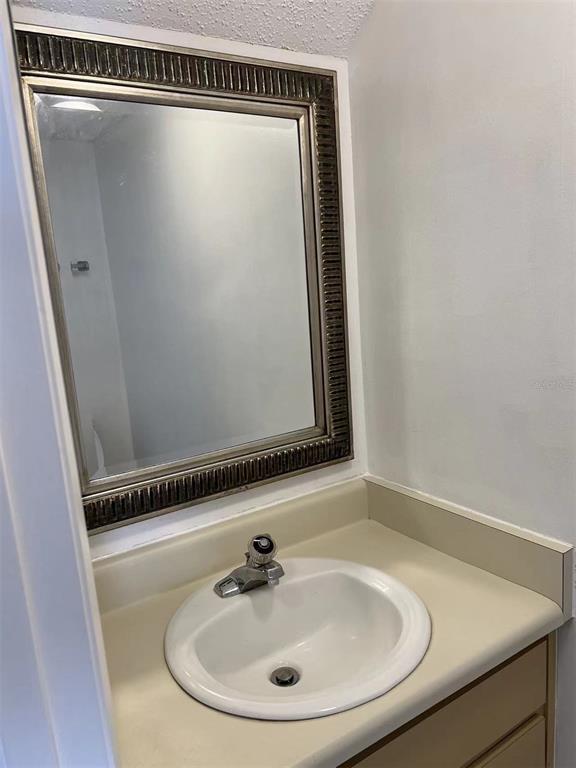 5812 Windhover Drive, Unit 5812 Orlando, FL 32819 - Photo 13 of 27 a bathroom with a sink and mirror