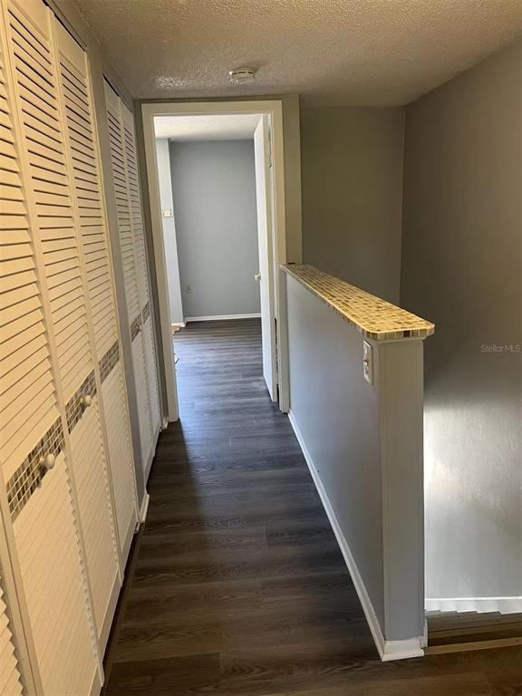 5812 Windhover Drive, Unit 5812 Orlando, FL 32819 - Photo 16 of 27 a view of a hallway with wooden floor and staircase