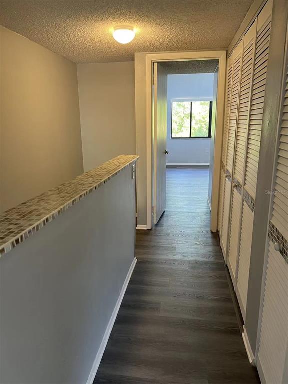 5812 Windhover Drive, Unit 5812 Orlando, FL 32819 - Photo 17 of 27 a view of a hallway with wooden floor and staircase