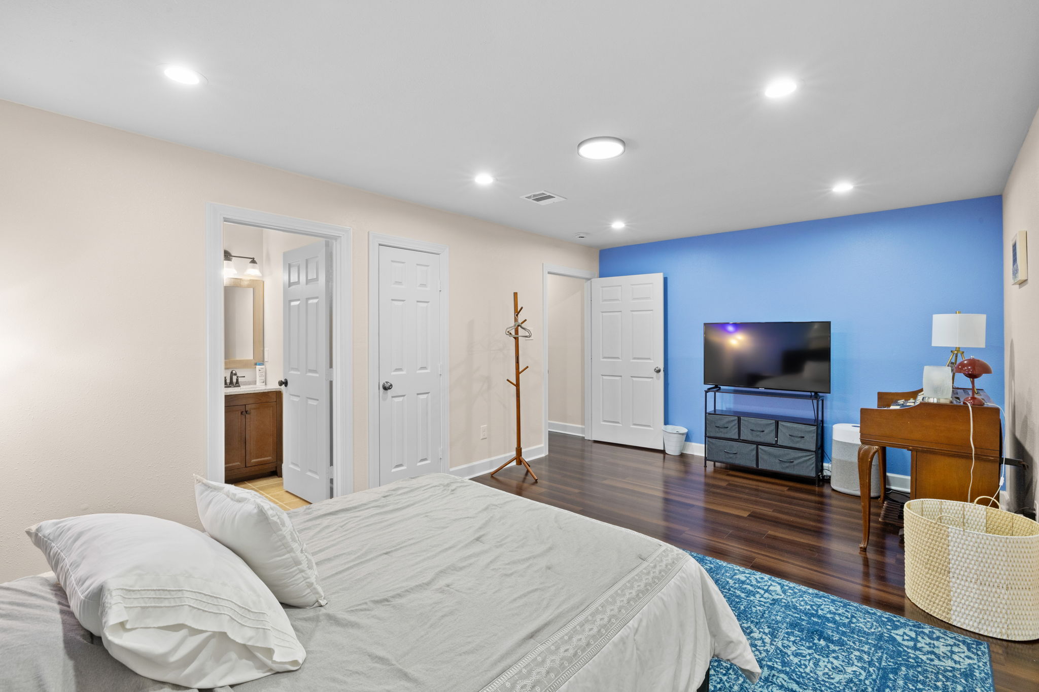 907 East 53rd Street Austin, TX 78751 - Photo 25 of 36 Rich hardwood flooring and cool blue accent wall define this bright, comfortable bedroom space.