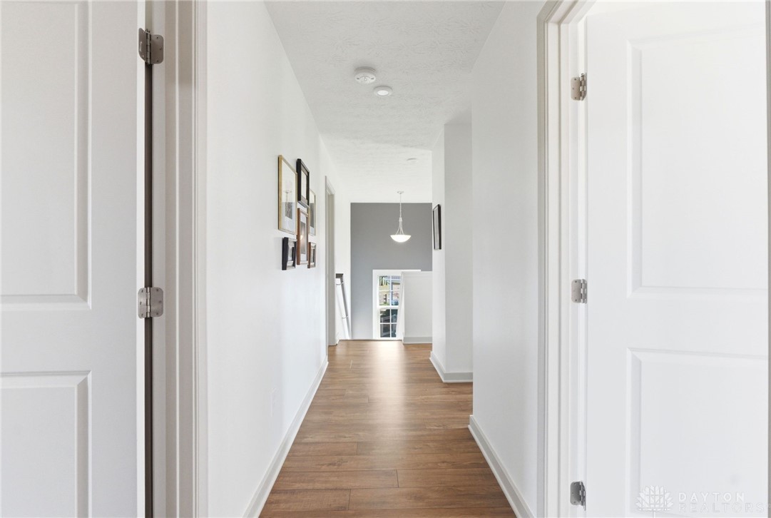 7900 Timberview Court Franklin, OH 45005 - Photo 40 of 60 This bright hallway connects spaces with elegant wood flooring and a classic pendant light.