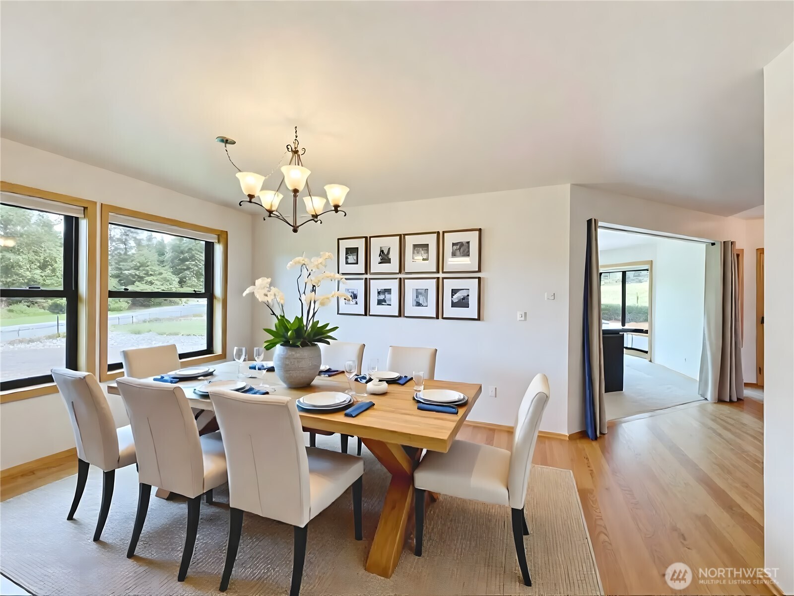 412 Doe Run Road Sequim, WA 98382 - Photo 15 of 40 a dining room with wooden floor a chandelier a wooden table and chairs