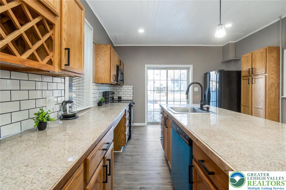 2213 Village Road Orefield, PA 18069 - Photo 25 of 41 a kitchen with stainless steel appliances granite countertop a sink a stove and a wooden floors