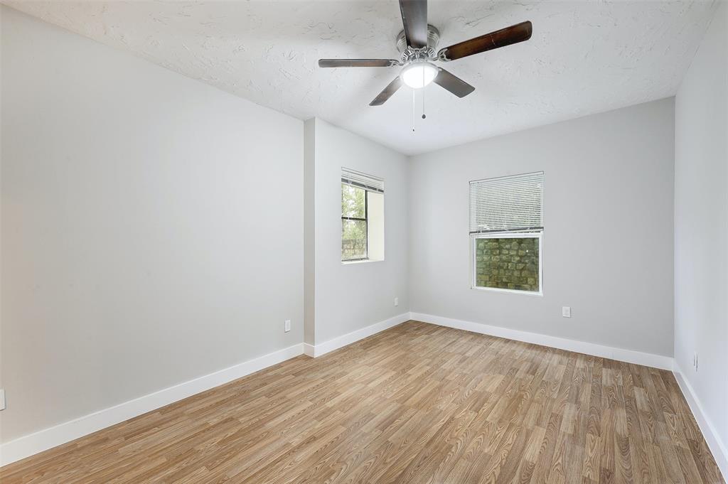 2511 San Gabriel Street Austin, TX 78705 - Photo 23 of 25 an empty room with wooden floor ceiling fan and windows