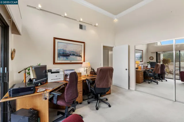 a view of a workspace with furniture and a window