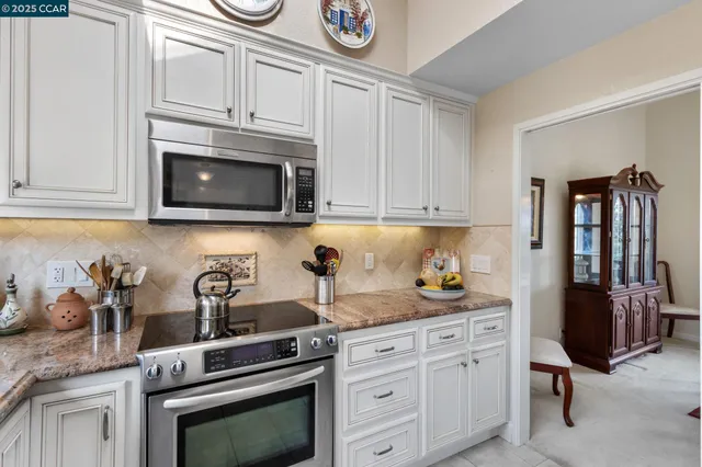 a kitchen with stainless steel appliances granite countertop a stove a microwave and cabinets