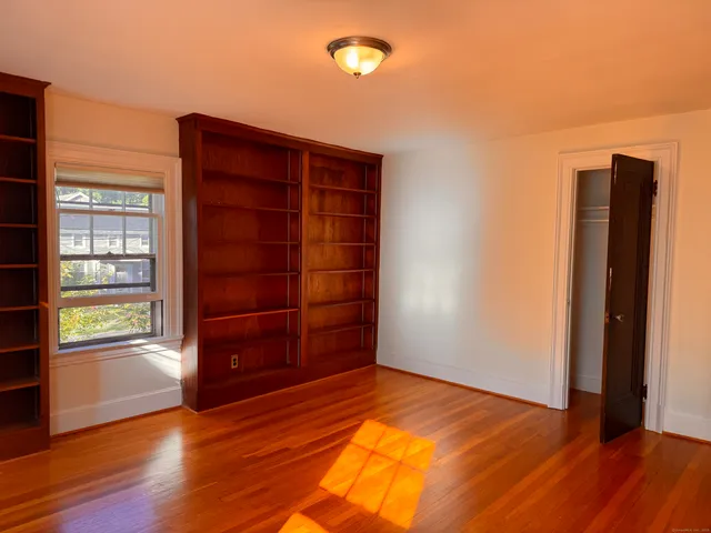 an empty room with wooden floor and closet