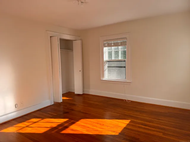 a view of a room with wooden floor and a window