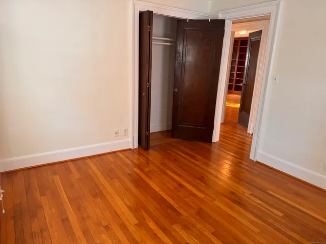 an empty room with wooden floor and closet