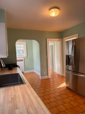 a kitchen with granite countertop a refrigerator and a sink