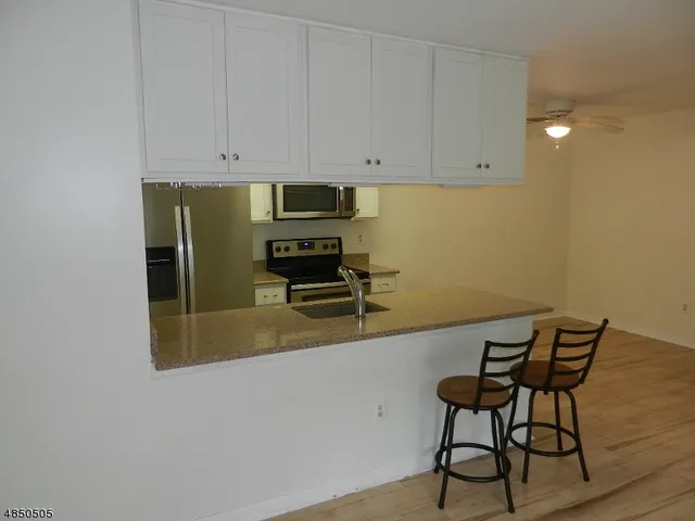 a kitchen with a chair and cabinets
