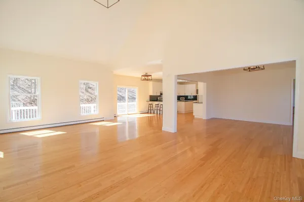 a view of empty room with wooden floor and windows