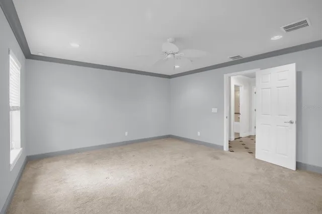 an empty room with a ceiling fan and a window
