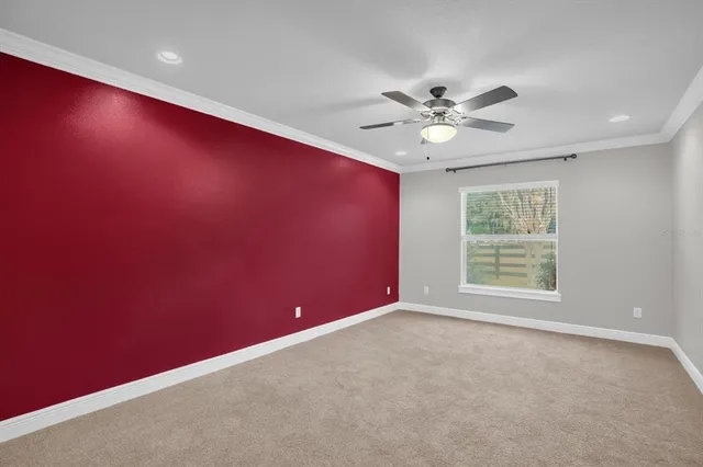 an empty room with a window and a fan